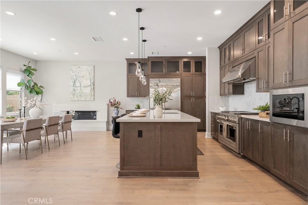 84 Rockinghorse Irvine, CA 92602 - Photo 13 of 63 a kitchen with stainless steel appliances granite countertop a stove top oven a sink a dining table and chairs