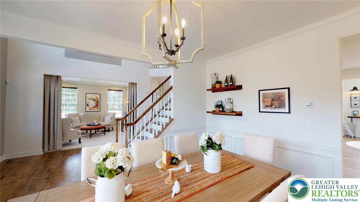 5137 Schantz Road, Unit THE ROOSEVELT Allentown, PA 18104 - Photo 11 of 39 a dining room with wooden floor a chandelier a wooden table and chairs