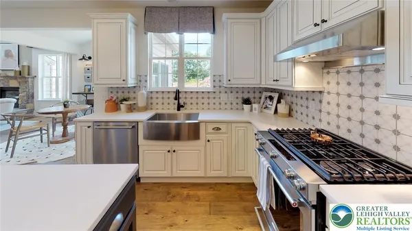 a kitchen with stainless steel appliances a dining table chairs a sink and white appliances