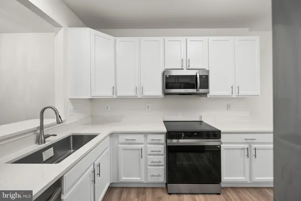 a kitchen with stainless steel appliances granite countertop a sink a stove a microwave and cabinets