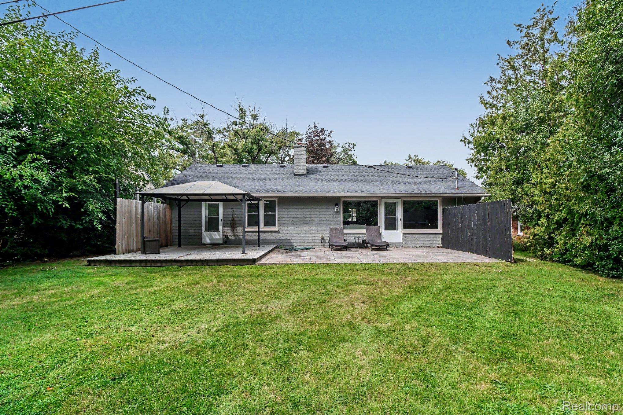 2373 Rutherford Road Bloomfield Hills, MI 48302 - Photo 24 of 28 Expansive backyard featuring a manicured lawn, a paved patio area, and a wood deck with a gazebo