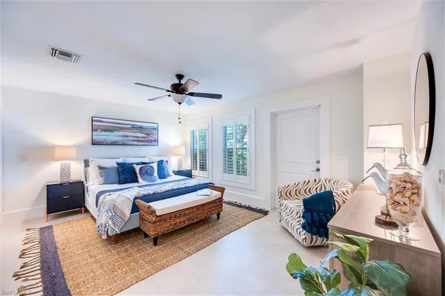 a spacious bedroom with a bed a couch and a window