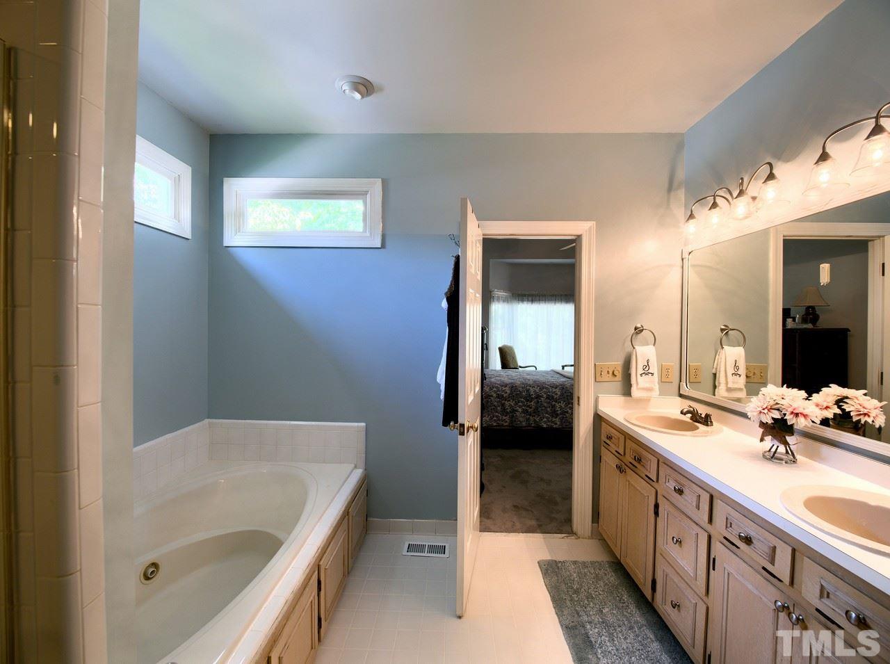 7901 Sandy Bottom Way Raleigh, NC 27613 - Photo 14 of 28 a spacious bathroom with a tub sink and mirror