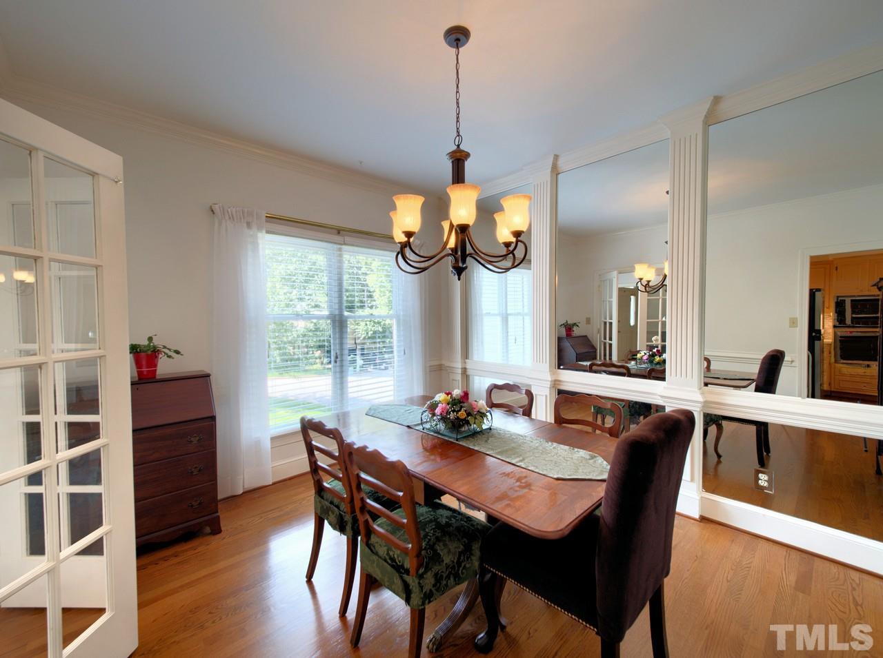 7901 Sandy Bottom Way Raleigh, NC 27613 - Photo 7 of 28 a dining room with wooden floor a chandelier a wooden table and chairs