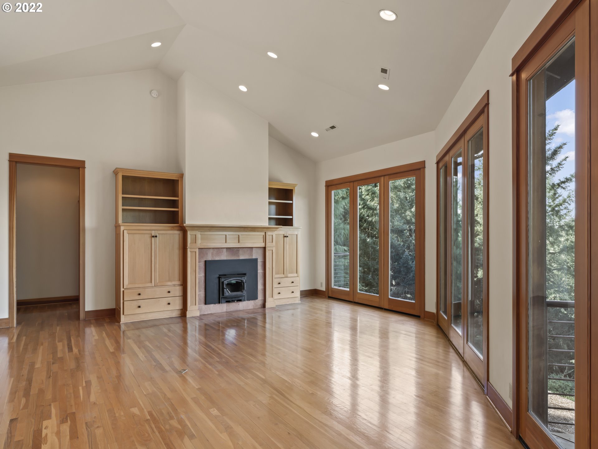 30923 Fox Hollow Road Eugene, OR 97405 - Photo 11 of 31 a view of an empty room with wooden floor fireplace and a window