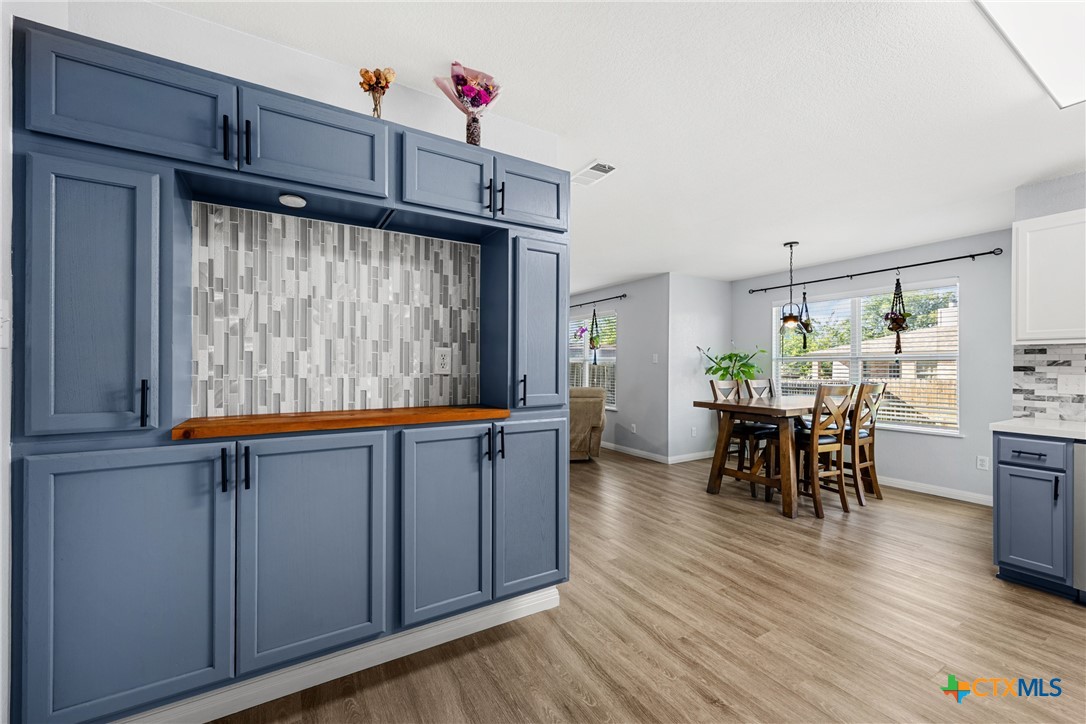 3410 Regency Court Killeen, TX 76549 - Photo 22 of 27 a kitchen with granite countertop wooden floors and wooden cabinets
