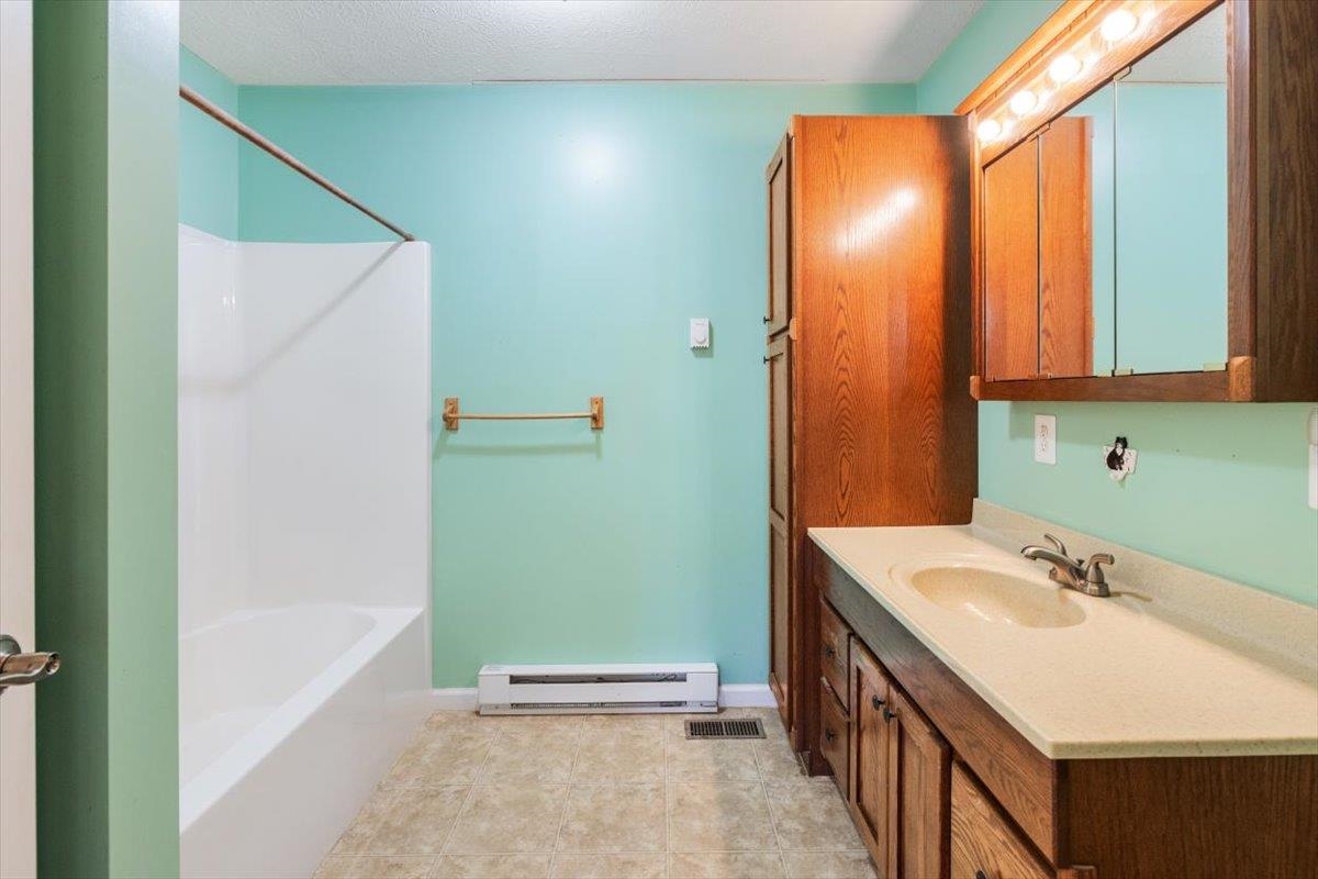 1182 Mullins Road Rio, WV 26755 - Photo 12 of 37 a bathroom with a sink a mirror and a bathtub