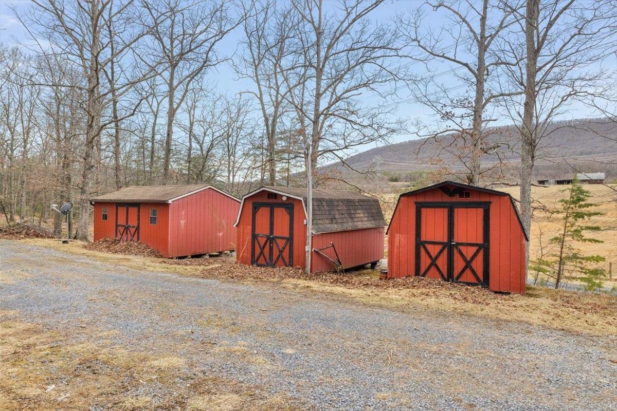 1182 Mullins Road Rio, WV 26755 - Photo 26 of 37 a big house with large trees and wooden fence