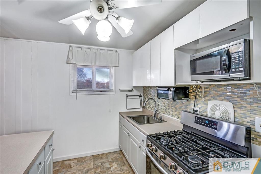 3020 Cheesequake Road Old Bridge, NJ 08859 - Photo 13 of 25 a kitchen with a stove a sink and a microwave