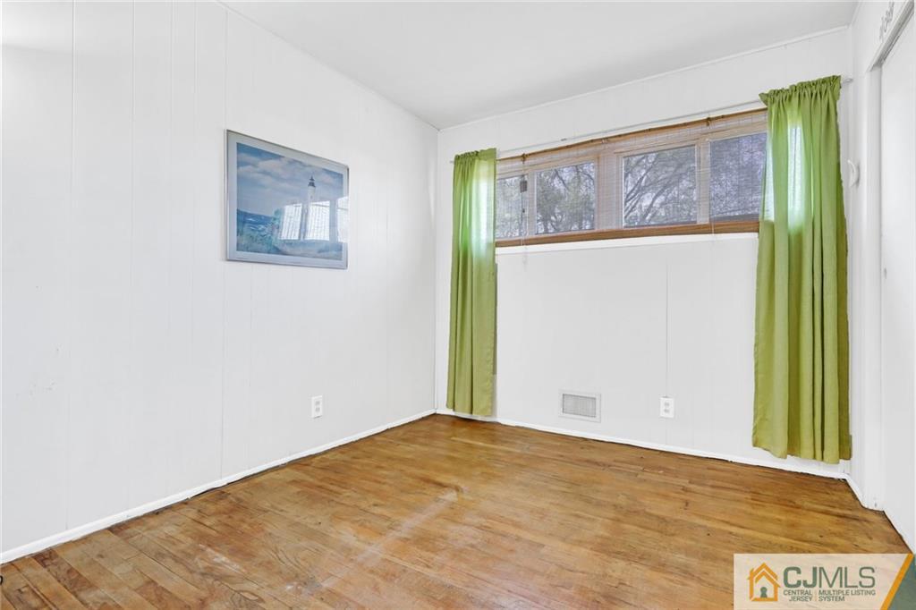 3020 Cheesequake Road Old Bridge, NJ 08859 - Photo 17 of 25 a view of an empty room with wooden floor and a window