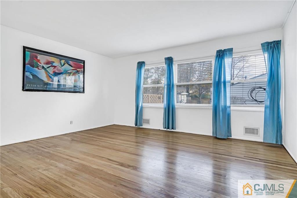 3020 Cheesequake Road Old Bridge, NJ 08859 - Photo 7 of 25 a view of an empty room with wooden floor and a window