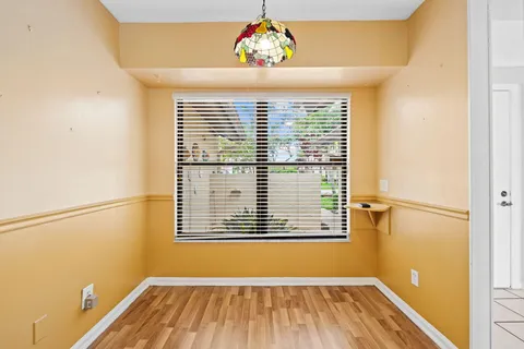 a view of a room with wooden floor and a window