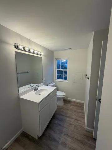 a spacious bathroom with a double vanity sink toilet and mirror