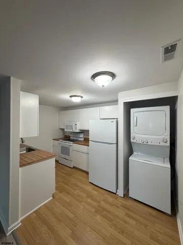a kitchen with a sink cabinets stainless steel appliances and wooden floor