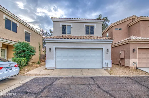 a view of a house with a garage and a car parked in garage