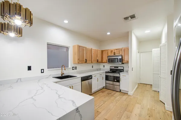 a kitchen with stainless steel appliances granite countertop a sink stove and refrigerator