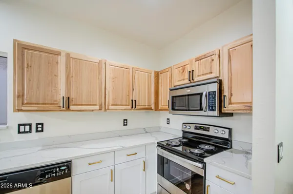 a kitchen with granite countertop a sink cabinets and stainless steel appliances
