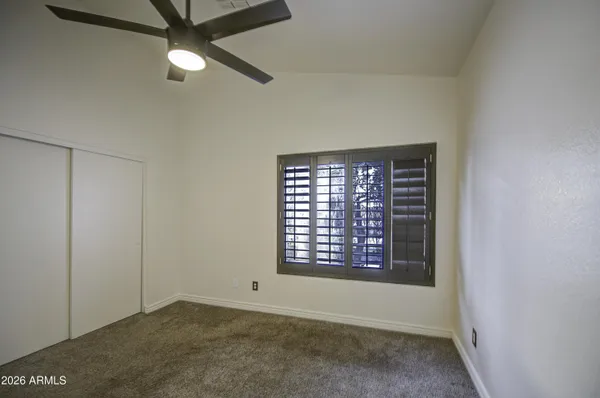 an empty room with windows and fan