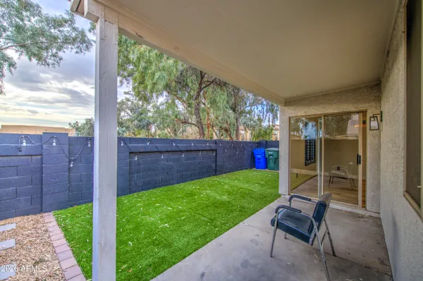 a front view of a house with a garden and chairs