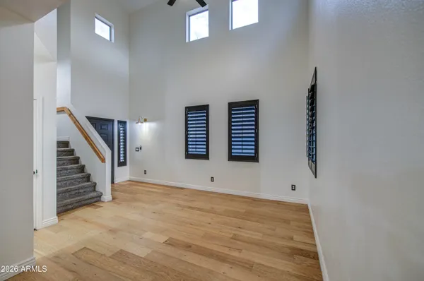 a view of an empty room with stairs and window