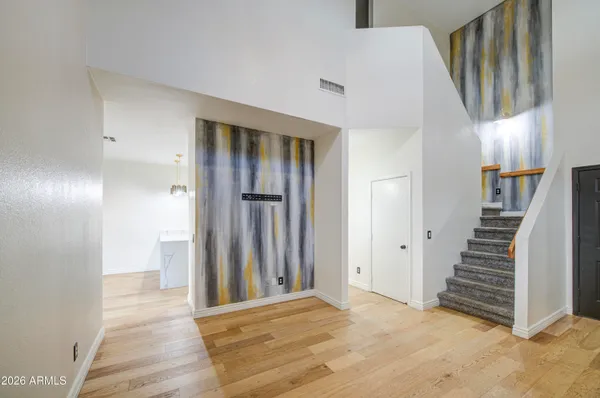 a view of a livingroom with wooden floor and stairs