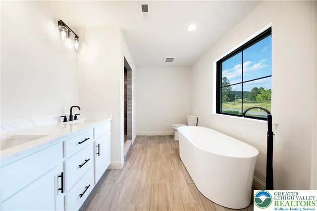 a spacious bathroom with a bathtub and a sink