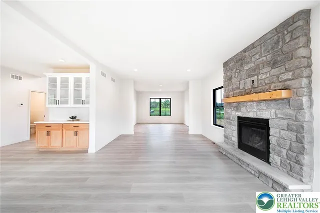 a view of an empty room with a fireplace and wooden floor