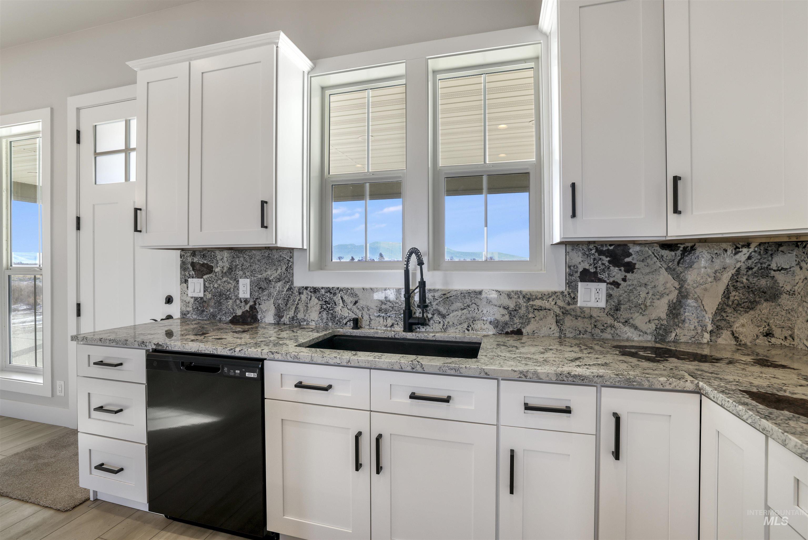 262 Ferdinand Circle Burley, ID 83318 - Photo 16 of 50 Kitchen featuring white cabinets, dishwasher, light stone countertops, and decorative backsplash