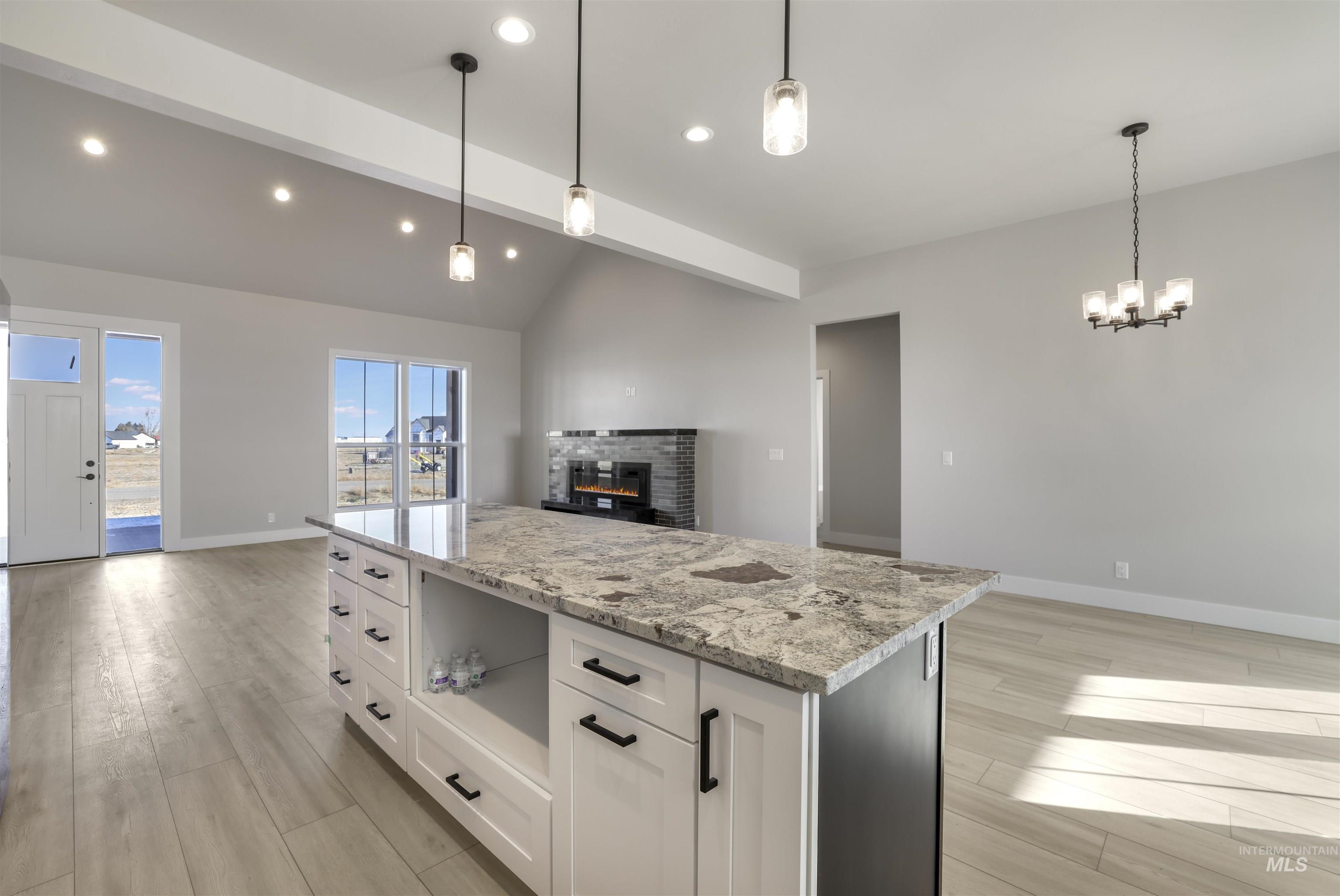 262 Ferdinand Circle Burley, ID 83318 - Photo 50 of 50 Kitchen featuring open floor plan, white cabinets, light stone countertops, a kitchen island, and light wood-type flooring