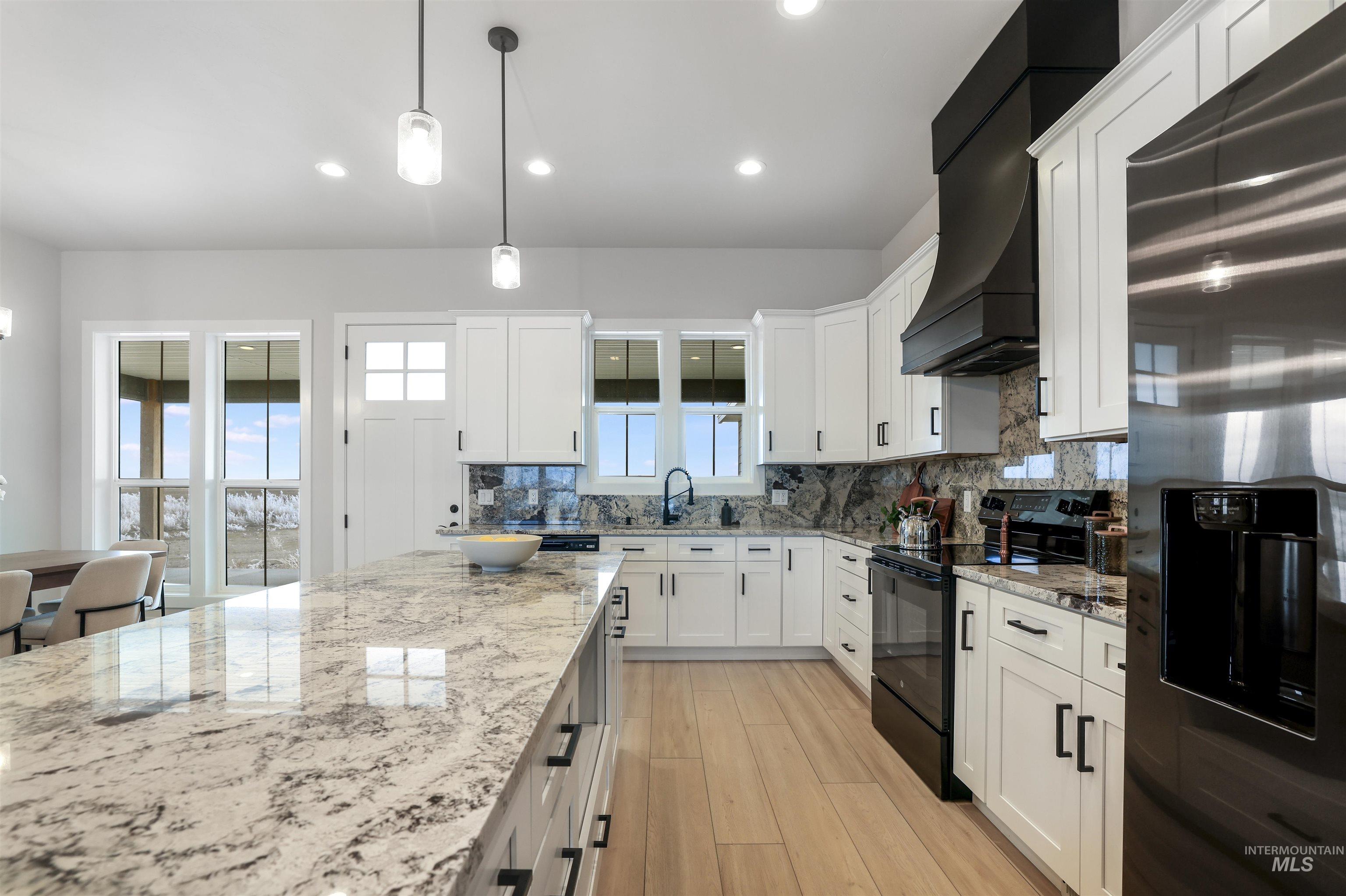 262 Ferdinand Circle Burley, ID 83318 - Photo 17 of 50 Kitchen featuring stainless steel refrigerator with ice dispenser, decorative light fixtures, black range with electric stovetop, white cabinets, and recessed lighting