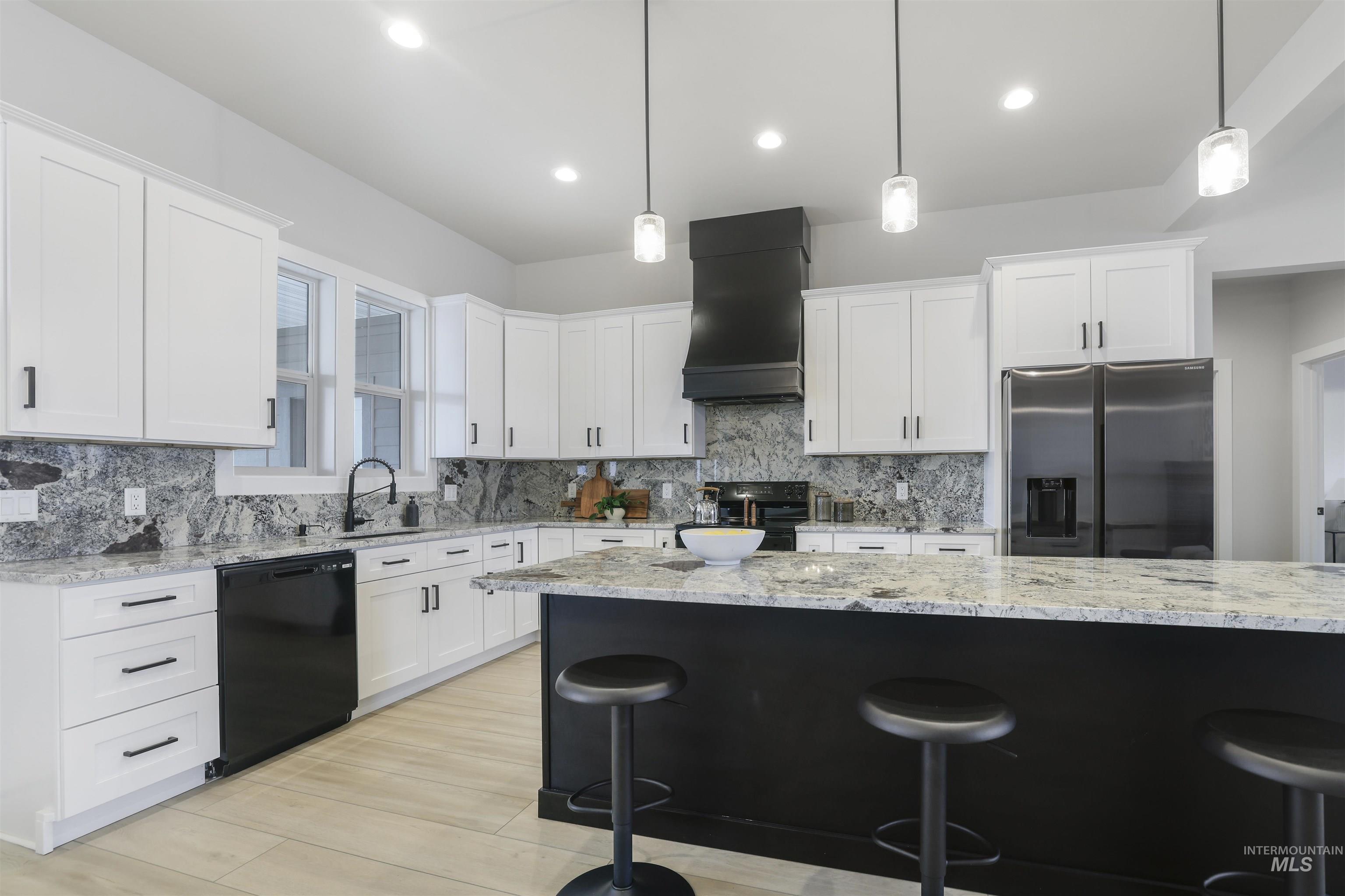 262 Ferdinand Circle Burley, ID 83318 - Photo 18 of 50 Kitchen with pendant lighting, a breakfast bar, light stone counters, black appliances, and white cabinetry