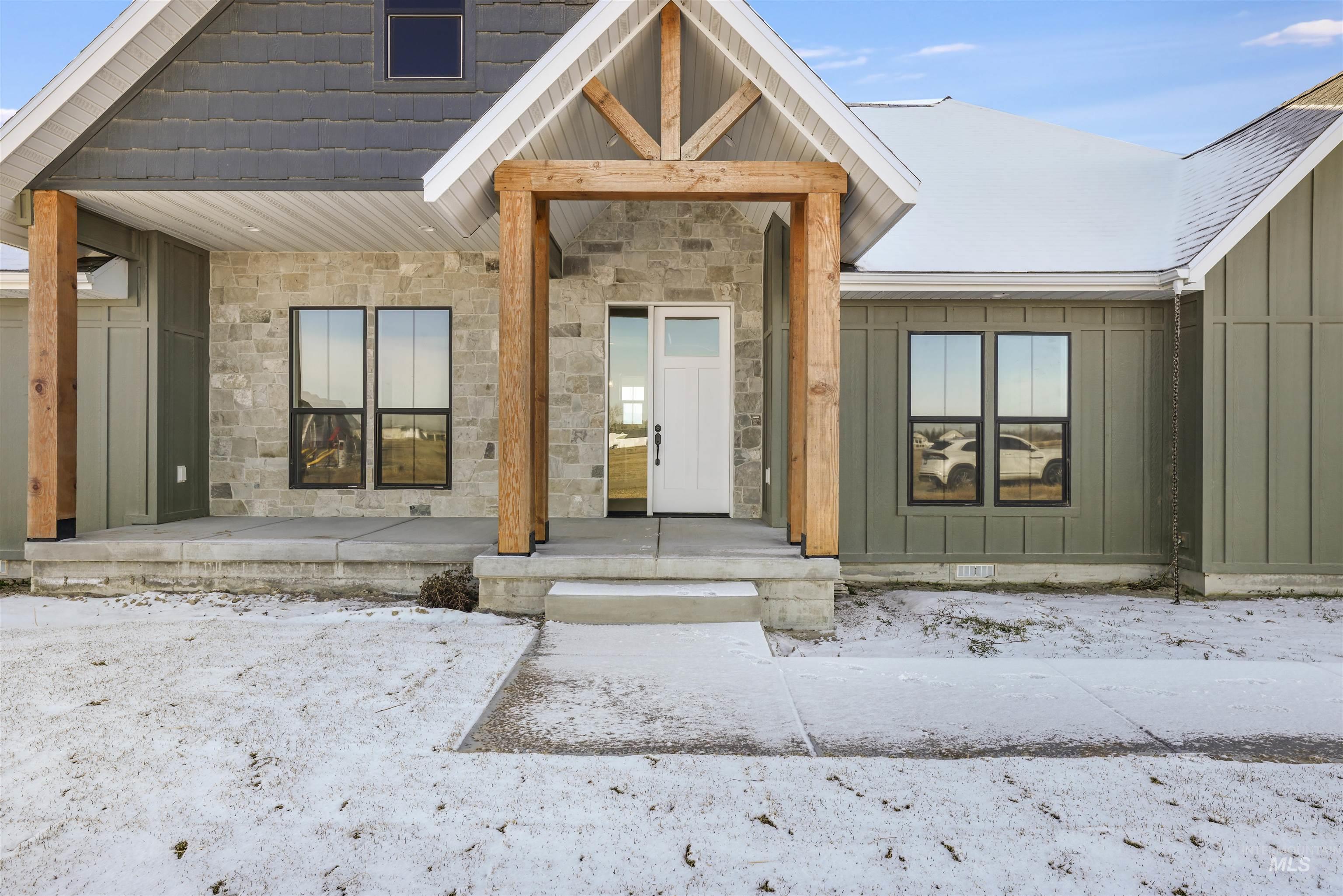 262 Ferdinand Circle Burley, ID 83318 - Photo 2 of 50 Snow covered property entrance featuring board and batten siding, stone siding, and covered porch