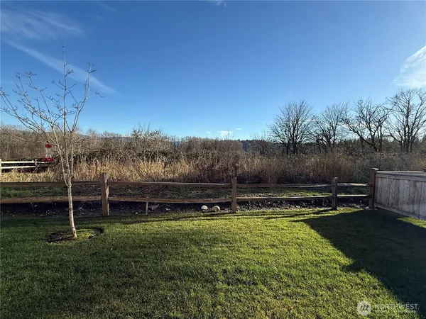 a view of a yard with wooden fence