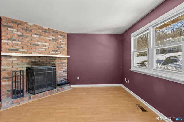 an empty room with a fireplace and windows