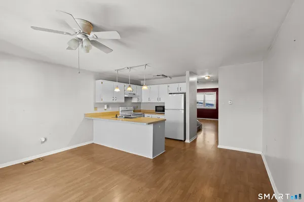 a view of a kitchen with a sink and wooden floor
