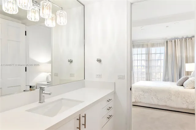 a bedroom with a sink and a large mirror