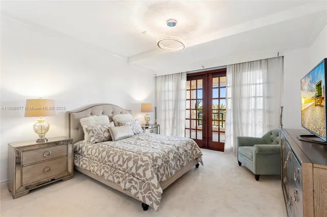 a bedroom with a bed and a flat tv screen on dresser