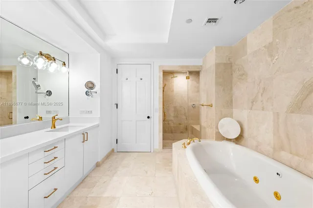 a bathroom with a tub sink mirror and shower