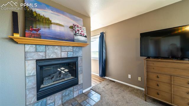 11125 Eureka Road Calhan, CO 80808 - Photo 20 of 44 Living room with carpet and a fireplace