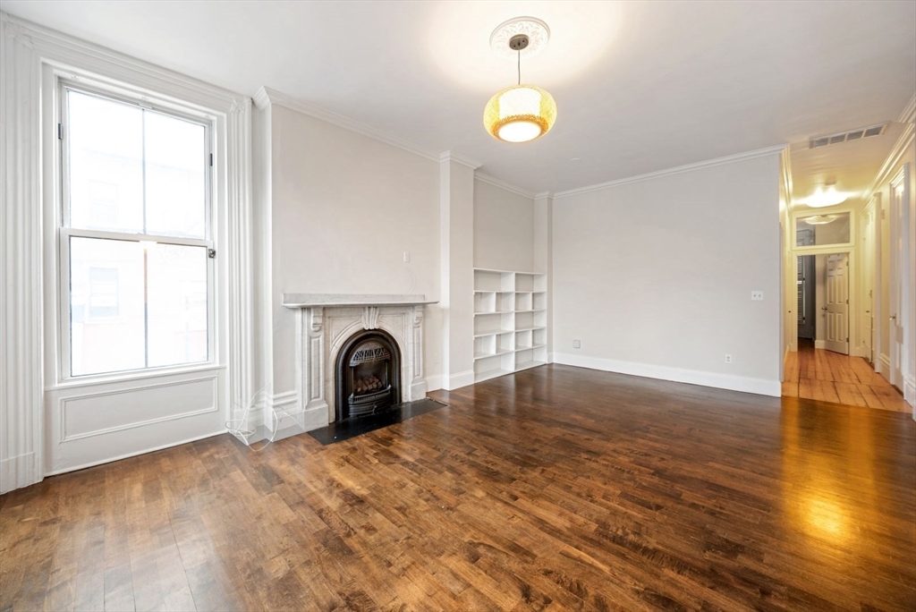 662 Tremont Street, Unit 3 Boston, MA 02118 - Photo 3 of 15 a view of empty room with wooden floor and fan