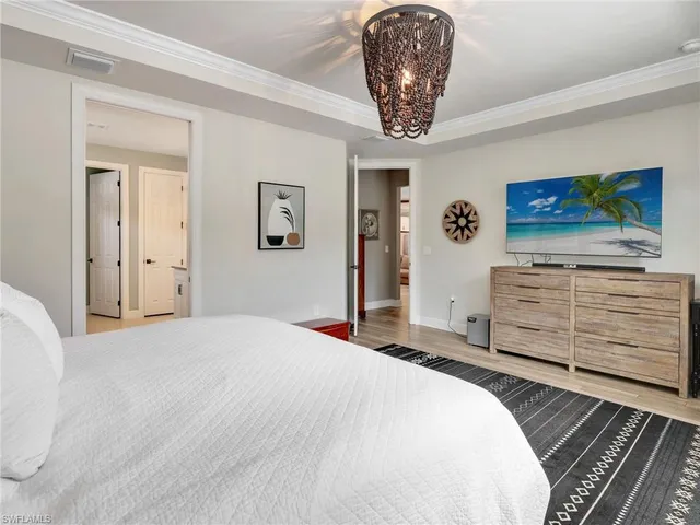 a bedroom with a bed and a chandelier