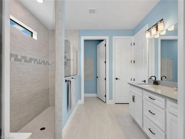 a bathroom with a double vanity sink a toilet and shower