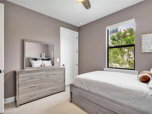 a bedroom with a bed and large windows