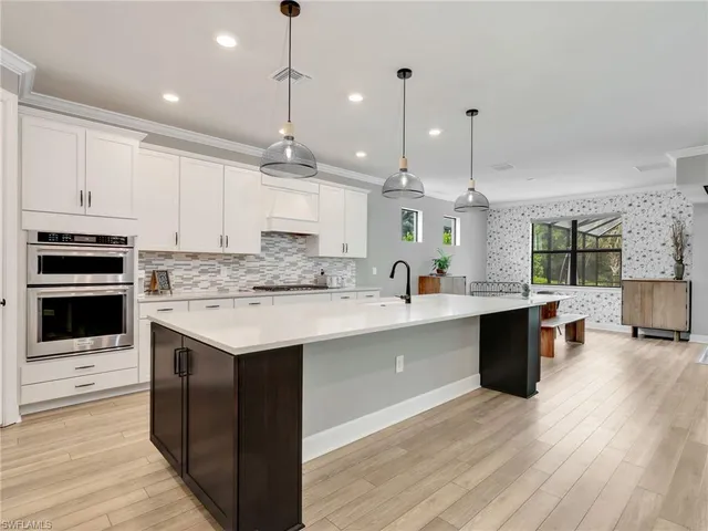 a kitchen with kitchen island granite countertop a sink appliances and cabinets