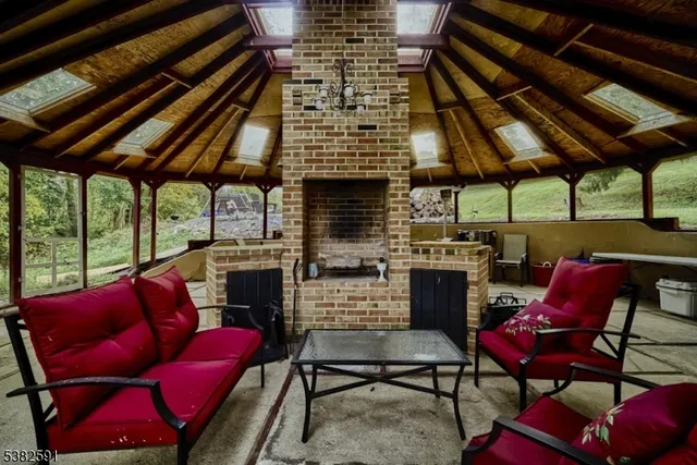 an empty room with wooden floor fireplace and windows