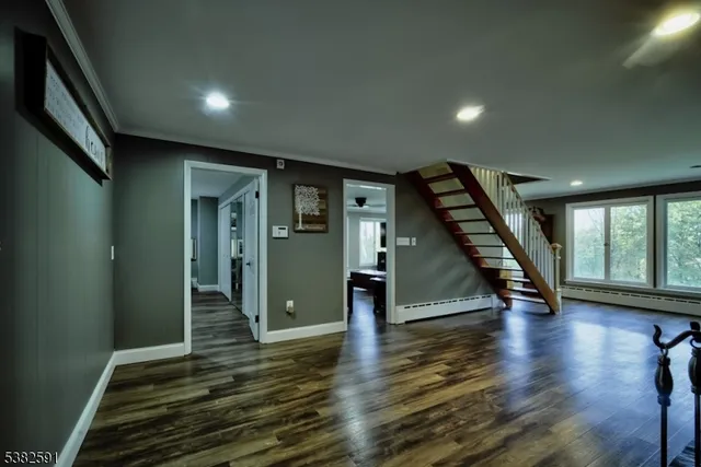 a view of a bedroom with wooden floor & cabinet