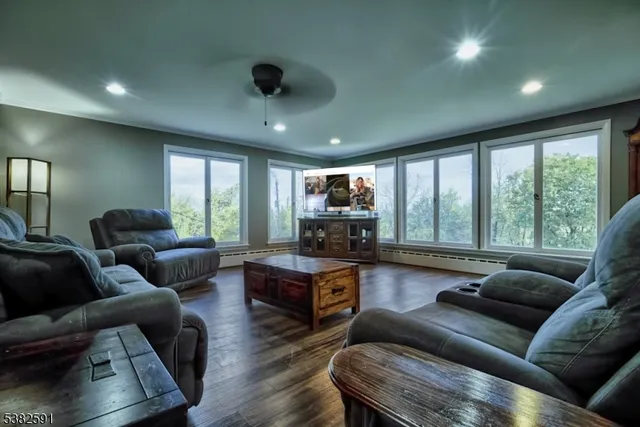 a spacious bedroom with a bed a dresser and a large window