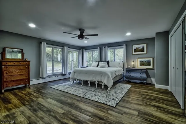 a view of a room with a large window and wooden floor