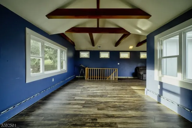 a view of hallway with window and wooden floor