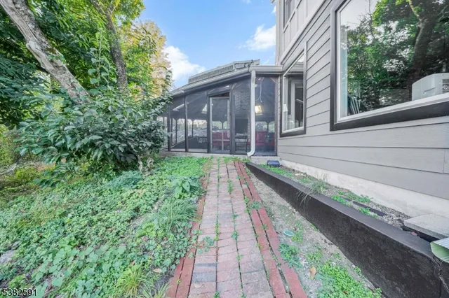 a view of a house with a small yard and a large tree